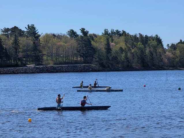 Two Lakehead concrete canoes racing on a lake