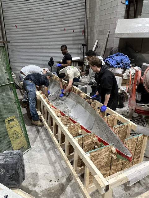 Lakehead students working together on a concrete canoe mould in the workshop